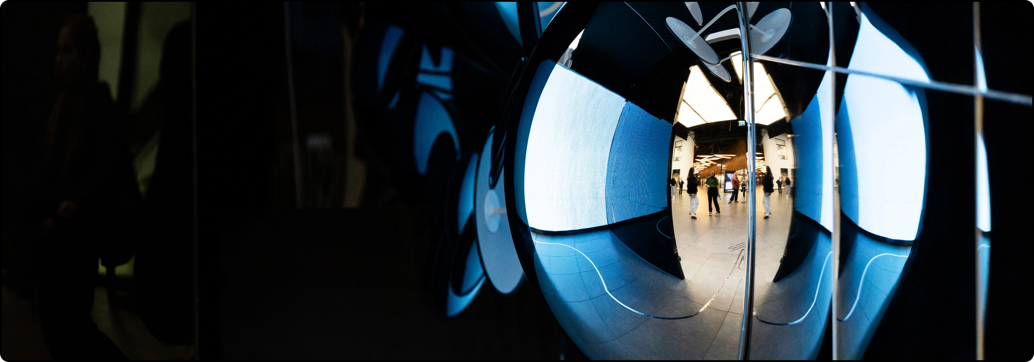 KTU Lifelong Learning page &ldquo;Contacts&rdquo; banner &ndash; mirrored surfaces with blue reflections and people in the background.